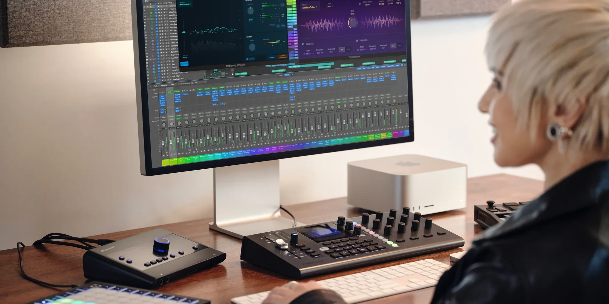 A music producer working in Apple Logic Pro on a Mac studio setup