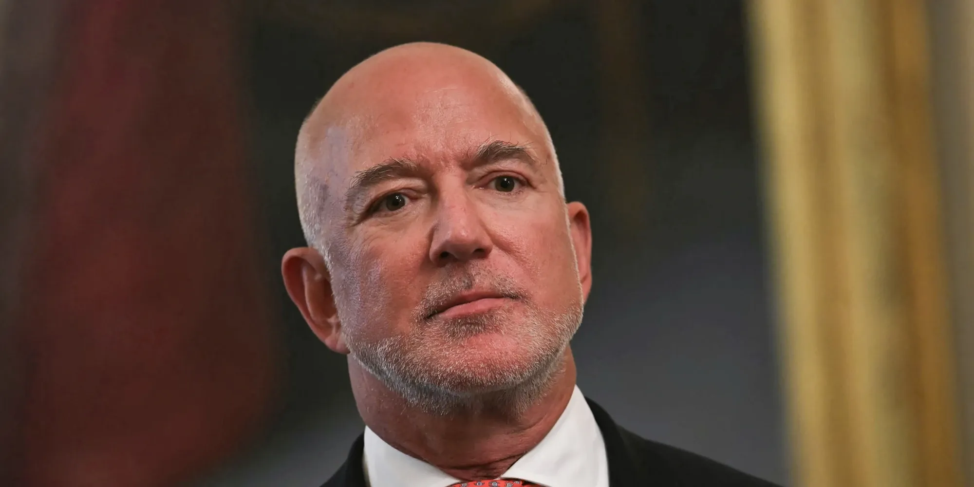 Jeff Bezos in a dark suit and red tie
